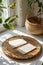 Mockup photo of one white blanks horizontal business cards, looking down, round rustic ceramic tray, light wooden tray,