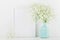 Mockup of picture frame decorated flowers in vase on white background with clean space for text and design your blogging.