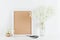 Mockup of picture frame decorated gypsophila flowers in vase on white working desk with clean space for text and design your blogg