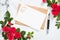 Mockup postcard with craft paper envelope, pen and rose flowers frame on marble stone background. Minimal style composition, flat