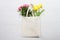 Mockup shopper handbag. Yellow tulips, pink roses. Wood background. Top view copy space shopping eco reusable bag. Mothers women