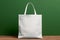 Mockup shopper tote bag handbag on isolated green wall background. Copy space shopping eco reusable bag. Grocery accessories.