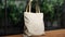 Mockup shopper tote bag handbag on table near interior plants background. Copy space shopping eco reusable bag. Grocery