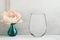 Mockup - stemless wine glass, next to a peony in a vase