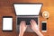 Mockup top view image of hands typing on laptop with blank white screen , mobile phone , tablet , coffee cup on vintage wood table