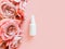 Mockup of unbranded white plastic spray bottle and pink roses on a pastel pink background. Bottle for branding and label.