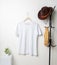 A mockup of a v-neck shirt that has been tastefully decorated with minimalistic design, hung in a way that exudes sophistication