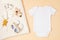 Mockup of white infant bodysuit made of organic cotton with eco friendly baby accessories