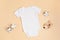 Mockup of white infant bodysuit made of organic cotton with eco friendly baby accessories