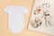 Mockup of white infant bodysuit made of organic cotton with eco friendly baby accessories