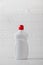 A mockup of a white plastic bottle with liquid dishwashing detergent with a white tiled background with bubbles