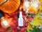 Mockup of white plastic spray bottle pumpkin, magic lights and bright autumn leaves. Atmospheric fall flatlay. Natural organic spa