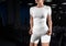 Mockup of a white sports set of underwear, a compression set, shorts, a T-shirt on a girl, against the background of inventory, in