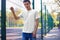 Mockup of a white T-shirt on a young guy against the background of the park, playground, front view