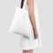 Mockup of a white totebag on a girl in a sundress, isolated on background