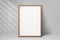 Mockup wood frame photo on wall. Mock up artwork picture framed. Vertical boarder with shadow. Empty board photoframe a4. Modern s