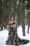 Model cosplay Snow Queen outdoor in winter pine forest