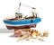 Model fishing boat with shells and starfishes on the white background