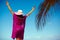 model girl in colorful cloth and sunhat behind blue beach