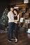 Model girl with slim body and a handsome bearded man posing in decorated for Christmas interior