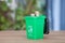 A model of a green trash can with dollar coins coming out of the lid