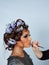 Model with hair in curlers and lipstick brush.