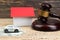 Model of house, car with judge's gavel and money on wooden background.