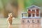 A model house model and Teddy Bear is placed on wood word sale.as background business concept and real estate concept