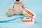 Model of jaw and stuffed bear animal with toothbrush isolated on blue background. Children dentist concept