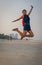 Model jumping in air on beach Thailand.