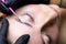 The model lies on the procedure of lamination of the eyebrows the master applies the composition for lamination on the eyebrows of
