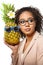 Model with pineapple in hands. African American Girl with Exotic Fruit. Cheerful woman with a smile relaxing on vacation. Image