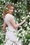 Model in pink dress posing in white flowers