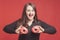 Model plus size with sweet donuts, happy girl smiling holding in hands cakes in black bodysuit. XXL female on red background