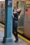 Model posing by the column at subway platform.