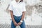 Model posing in plain tshirt against street wall