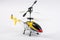 Model radio-controlled helicopter with remote control. Made of metal body, with plastic blades, yellow, blue and red color,isolate