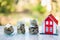Model of red roof and coins in a stack of glass bottles Concepts of saving money, saving money, investing to buy houses, real
