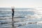 Model at the seaside in winter. With feet in the water with many reflections