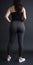 Model slim fit girl in gray yoga pants. standing with back to camera. Curvy body