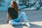 Model wearing plain tshirt and sunglasses posing over street wall