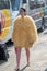 Model wears a woolly yellow jacket similar to a chick and pink tights