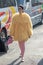 Model wears a woolly yellow jacket similar to a chick and pink tights