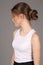 Model in white singlet standing profile. Close up. Gray background