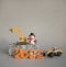 Models of toy orange excavator and loader stand on a piece of granite, souvenir snowman, new 2022 numbers