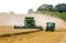 Modern 9780i cts john deere combine harvester cutting crops corn wheat barley working golden field