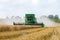 Modern 9780i cts john deere combine harvester cutting crops corn wheat barley working golden field