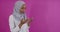 Modern African Muslim woman makes traditional prayer to God over colorful background