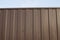 Modern aluminum fence of corrugated panel corrugated metal siding brown