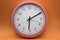 modern analog clock orange color on orange background